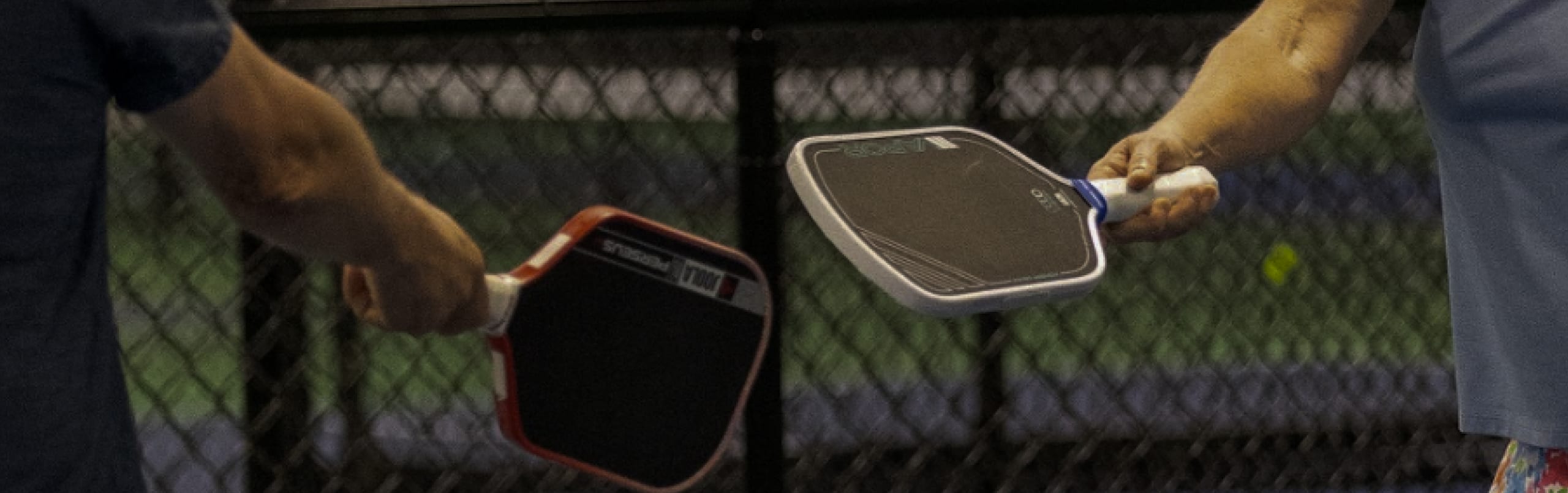 Two players tapping paddles at the net