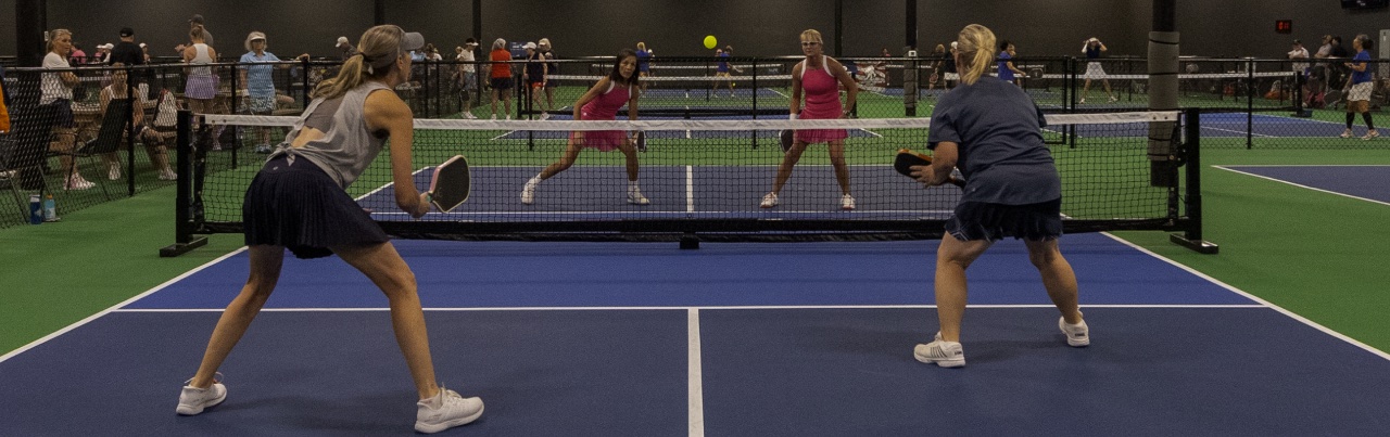 Players mid-rally on the indoor courts