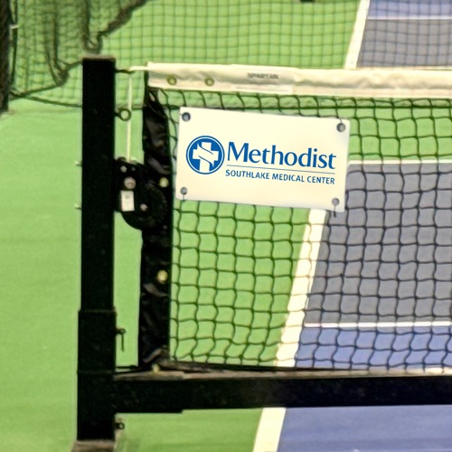 Sponsor banner displayed on a court net post